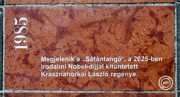 Az MTA sz�kh�z�n�l, a Sz�chenyi Istv�n t�ren, a Hat�rtalan t�rt�net c�m� m�alkot�s folyamatosan b�v�l� id�vonal, az �j k�vel a tavaly Nobel-d�jjal kit�ntetett �r� S�t�ntang� c�m�, 1985-�s reg�ny�r�l eml�keznek meg. K�p: MTI / Illy�s Tibor