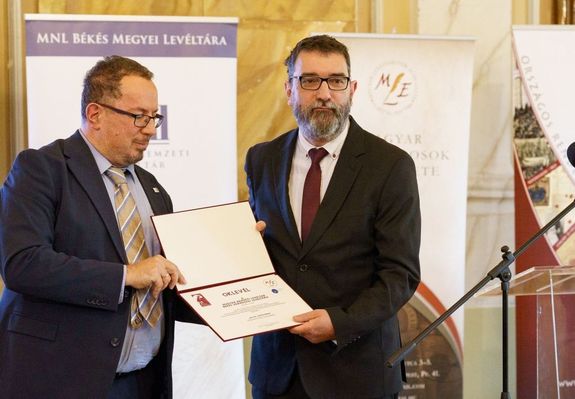 Az V Levltra 2024 djat dr. Kenyeres Istvn, a Magyar Levltrosok Egyesletnek elnke (balrl) adta t Sfr Gyulnak, az MNL Bks Vrmegyei Levltra igazgatjnak, a gyulai vroshza dsztermben. Kp forrsa: dr. Grgnyi Ern polgrmester Facebook-oldala