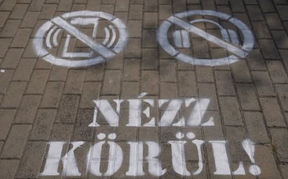  Jl lthat jelekkel hvjk fel a figyelmet a kzlekeds kzbeni telefonls vagy zenehallgats veszlyessgre, klnsen a vasti tjrkban. A piktogram a Balaton-parti teleplseken folytatdott, vasti tjrkban jelentek meg a figyelmeztet jelek. Kp forrsa: MTI