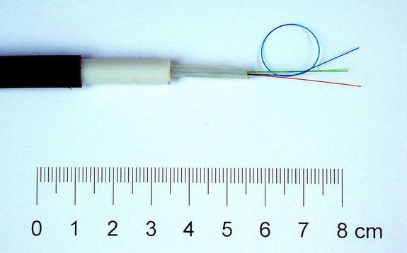  Az optikai k�belek olyan huzalok, sz�lak, amelyeket �vegb�l vagy m�anyagb�l k�sz�tenek, �s vel�k f�nyhull�mokat tov�bb�tanak. Ezekkel a k�belekkel az inform�ci�t (p�ld�ul hang, adat vagy k�p) nagy sebess�ggel �s nagy t�vols�gokon �t lehet tov�bb�tani. A k�pen optikai k�bel, n�gy optikai sz�llal. K�p: Z�tonyi S�ndor (ifj.) Fizped. Forr�s �s k�p: Wikip�dia