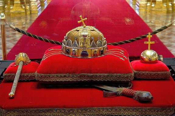 A f�ldreng�sbiztos vitrinben �rz�tt Szent Korona az Orsz�gh�z kupolacsarnok�ban. A Szent Koron�t �llaga meg�v�sa �rdek�ben, leveg� helyett nitrog�n veszi k�r�l. Megvil�g�t�sa sor�n nem �ri term�szetes f�ny. Forr�s: Wikip�dia. K�p forr�sa: parlament.hu